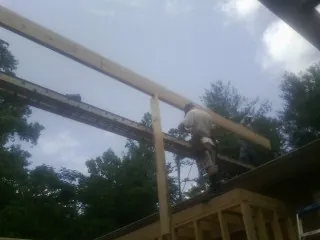 Carpenter setting a ridge beam over a new addition frame — Ice Dam Removal by Roofing Brothers in Altamahaw