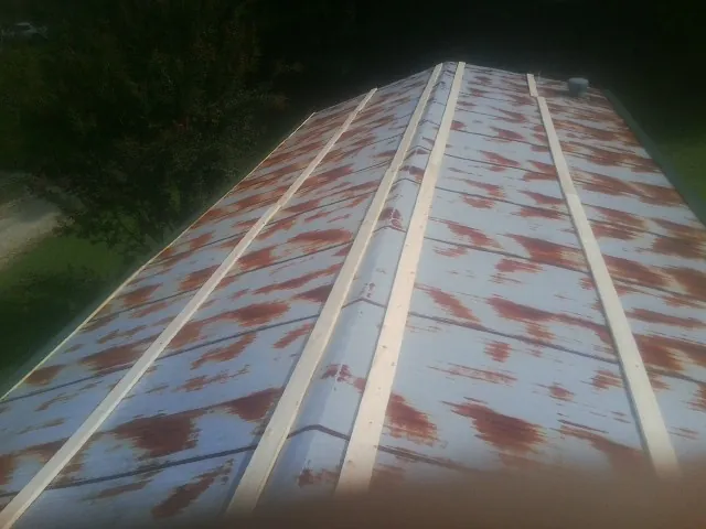 Rusted metal roof panels with new wood purlins before replacement — Storm Damage Roof Repair in Altamahaw by Roofing Brothers