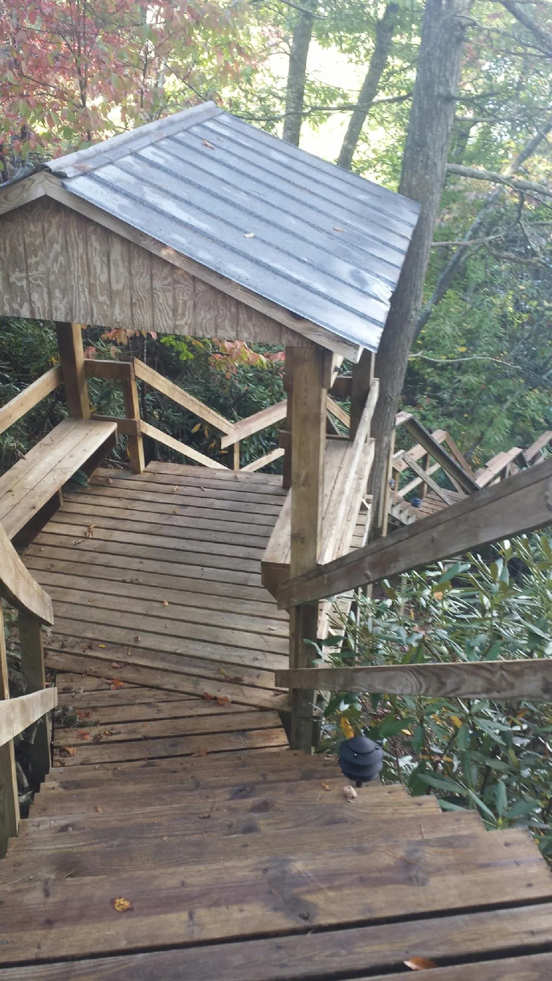Metal roofed shelter over wooden steps on a wooded walkway — Skylight Repair & Installation work by our crew in Altamahaw