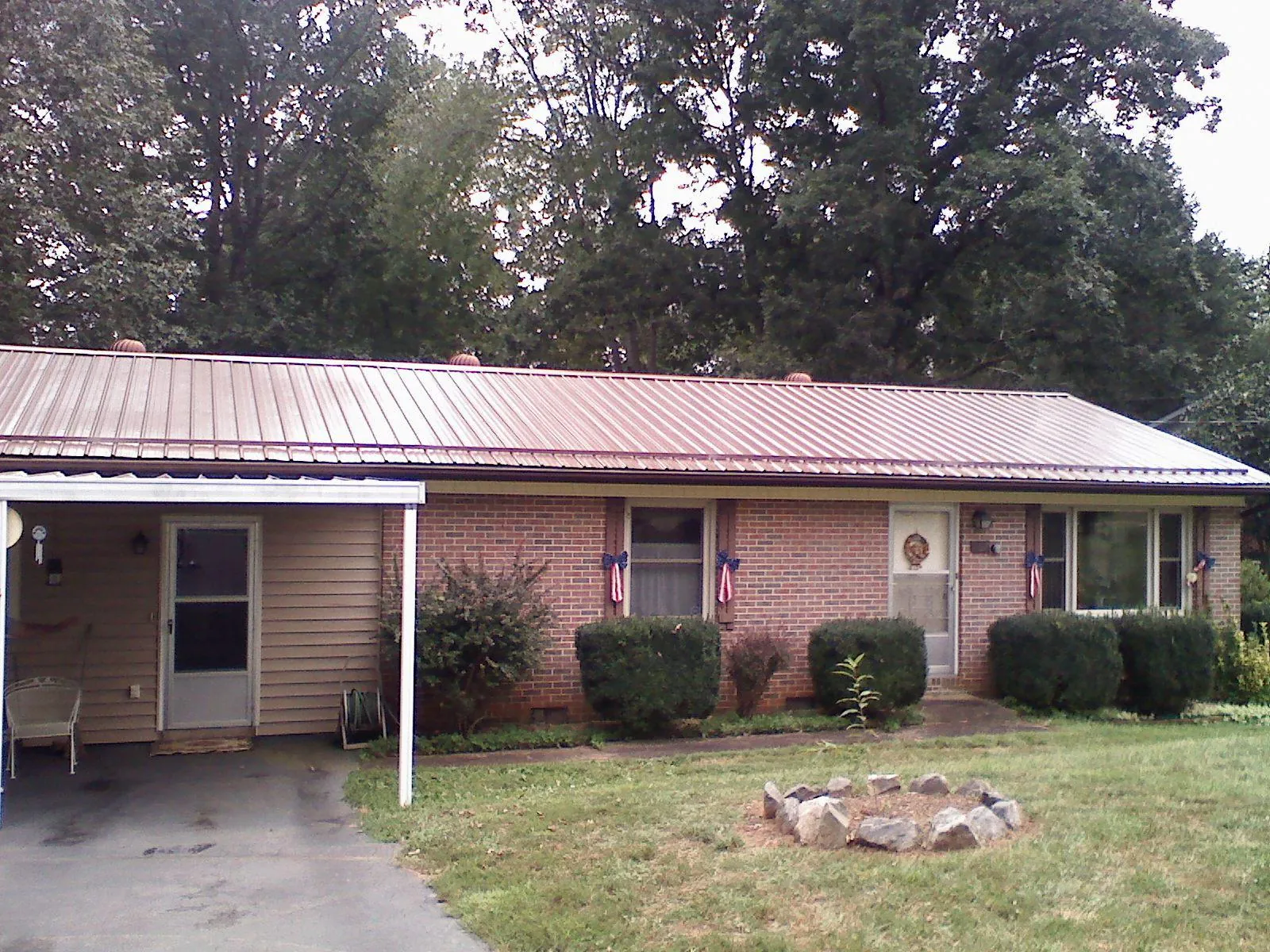 Bronze metal roof and carport on a brick ranch home — Roof Repair work by our crew in Altamahaw