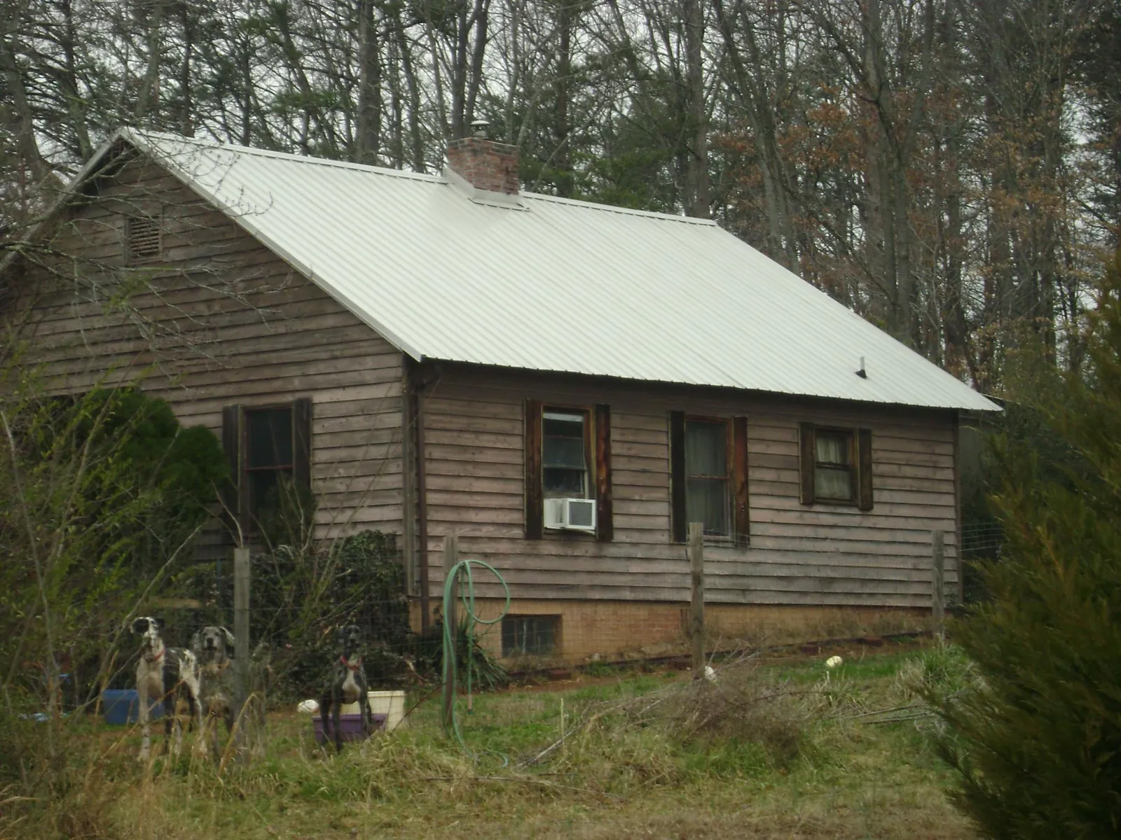White metal roof on an old wood sided farmhouse, from a Metal Roof Installation job in Altamahaw